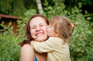 Happy young woman being kissed by a cute little girl; Shutterstock ID 108519002; PO: aol; Job: production; Client: drone