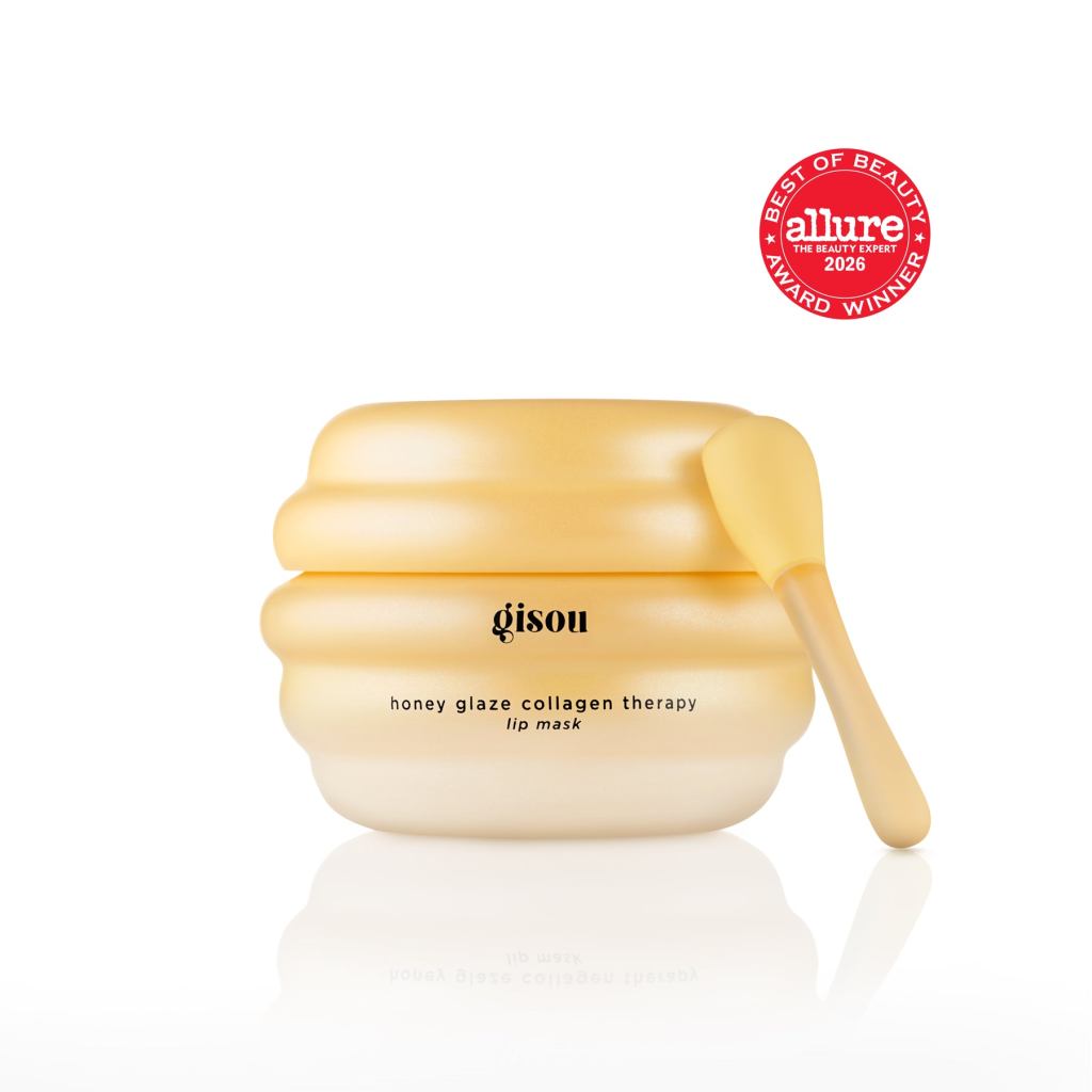 A jar of Gisou Honey Glaze Collagen Therapy Lip Mask with a honeycomb-inspired design and a small applicator, showcasing the product's smooth, golden color. Awarded 'Best of Beauty' by Allure for 2026.