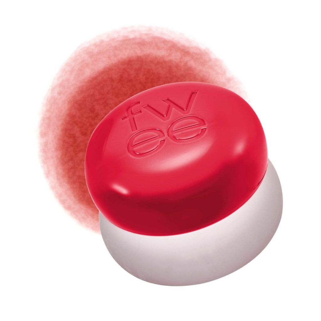 A round red cosmetic container with a white base, featuring the text 'fwee' embossed on the top, accompanied by a soft blush pigment background.