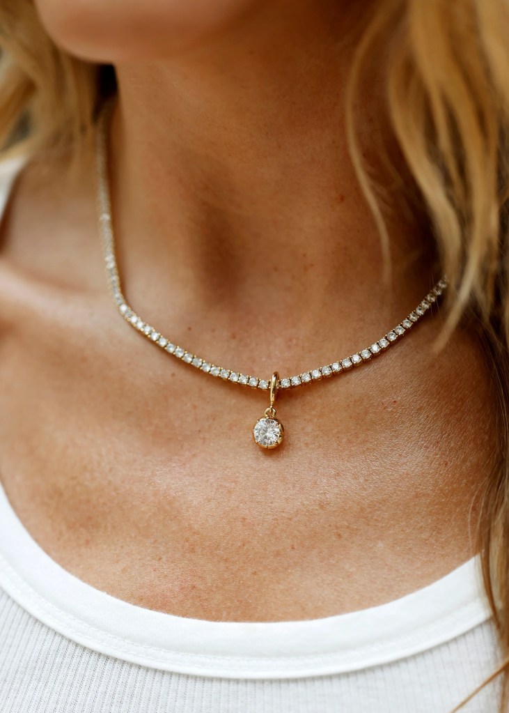 Close-up view of a woman's neck adorned with a diamond pendant necklace and a sparkling crystal choker.