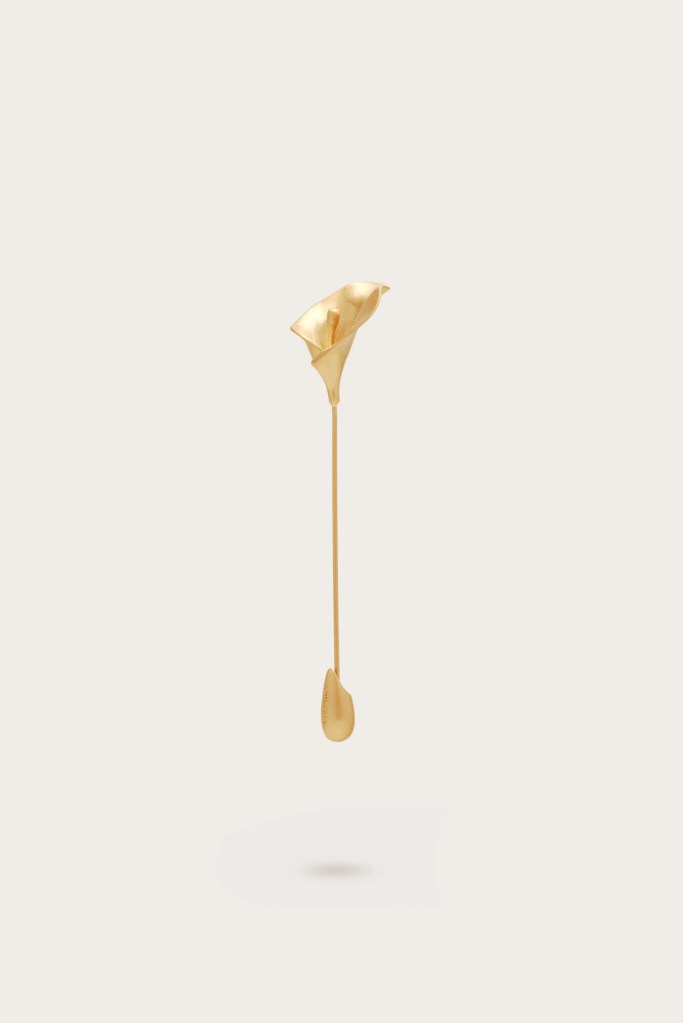A delicate gold sculpture resembling a calla lily, suspended with a slender stem and a droplet at the bottom.