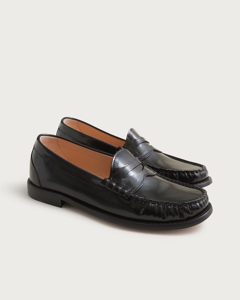 A pair of black leather loafers with a classic design, featuring a stitched detailing along the edges and a low heel.