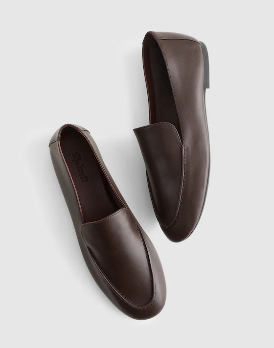 A pair of elegant brown leather slip-on shoes, featuring a smooth surface and minimalistic design.