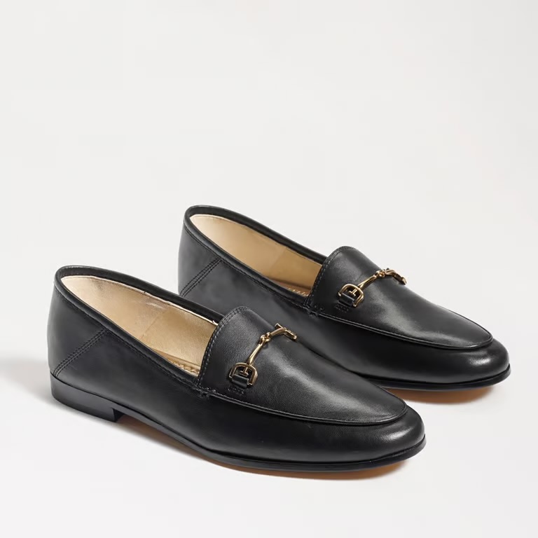 A pair of elegant black leather loafers featuring a gold buckle detail.