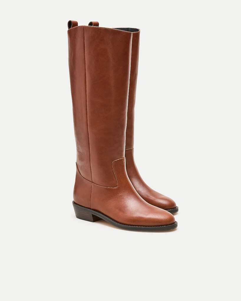 A pair of tall brown leather boots with a low heel and a sleek design.