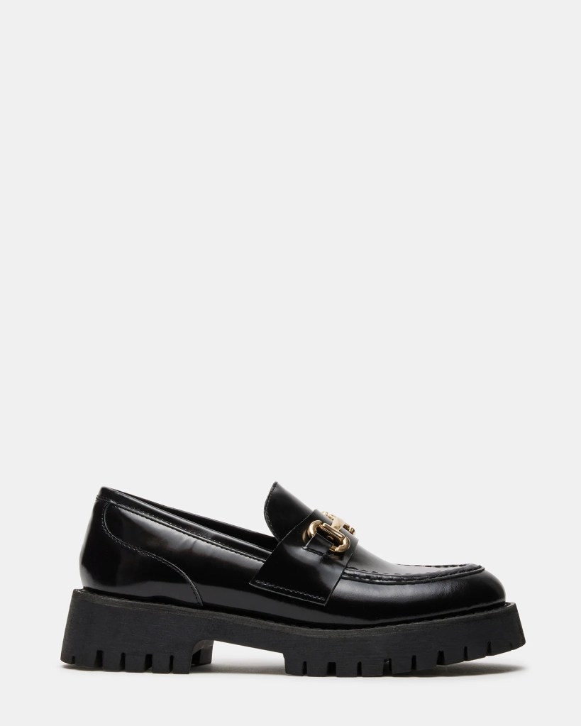 Black patent leather loafers with a chunky sole and decorative buckle detail on the side.