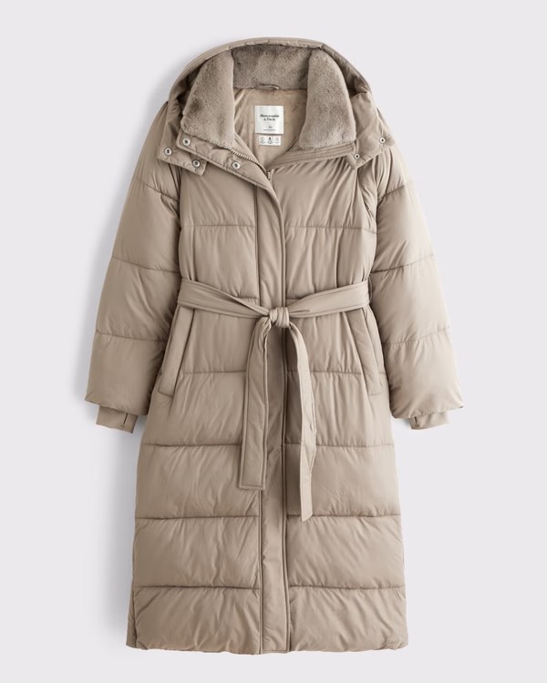 A beige padded long coat with a hood and a belted waist, featuring a soft inner lining.
