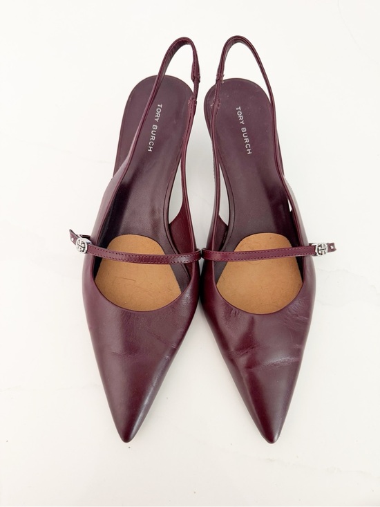 Pair of burgundy Tory Burch slingback high-heeled shoes with pointed toes and a strap across the instep.