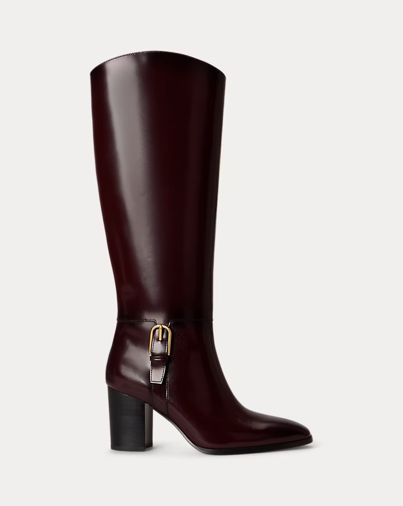 A stylish knee-high burgundy leather boot with a chunky heel and a decorative buckle.